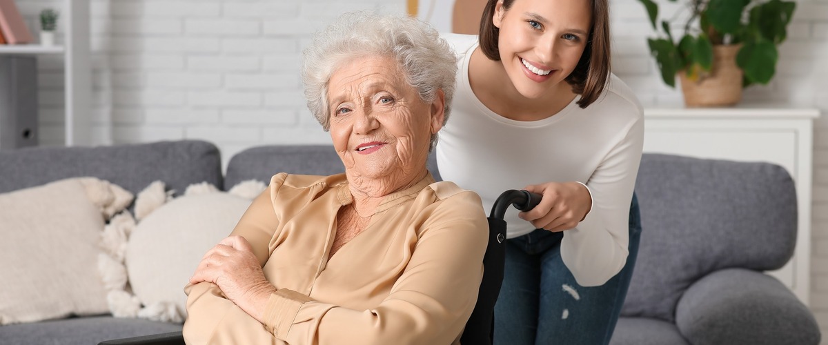 Seniorin im Rollstuhl und junge Frau haben gute Laune